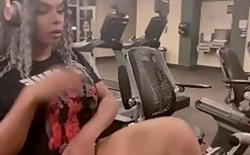 Using her sex toy to shoot a cumshot while working out in the gym